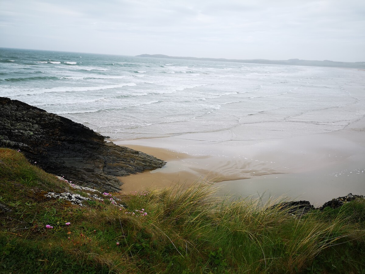 Iimage showing a beach with waves viewed from a cliff